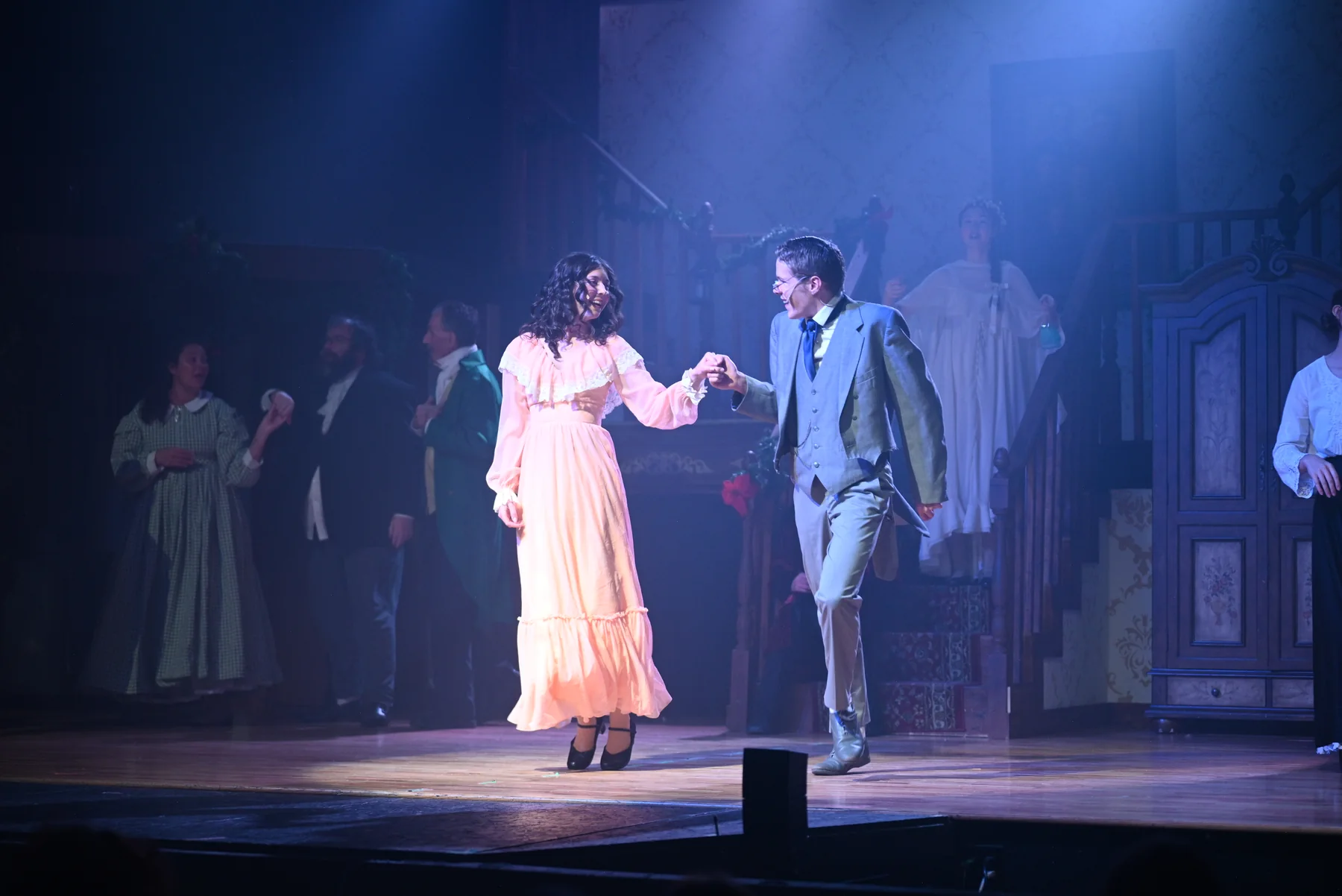 Young Scrooge and Belle dance together on the blue-lit stage in 2025.