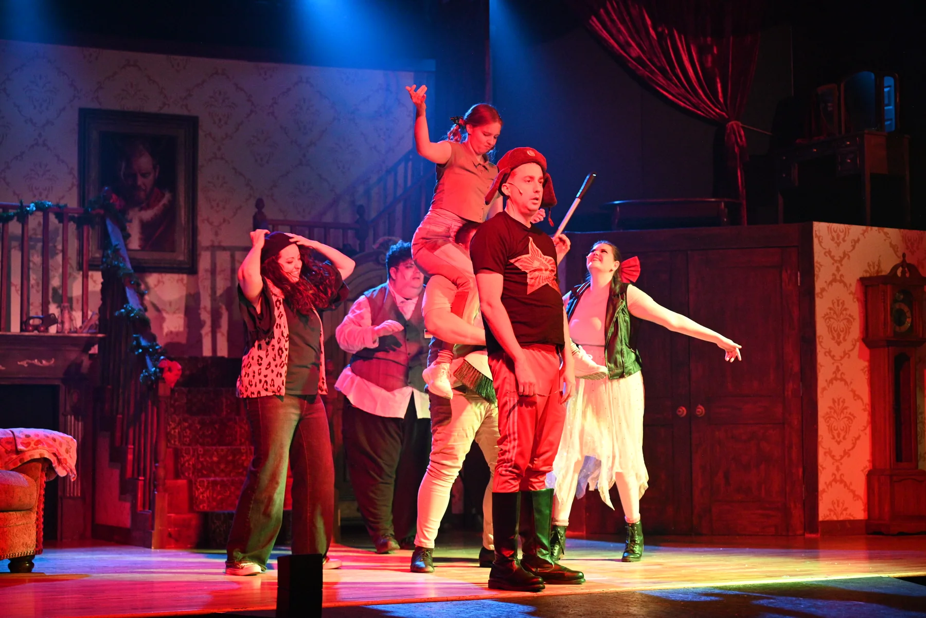 The 2025 ensemble performs a comic lift during a musical number.