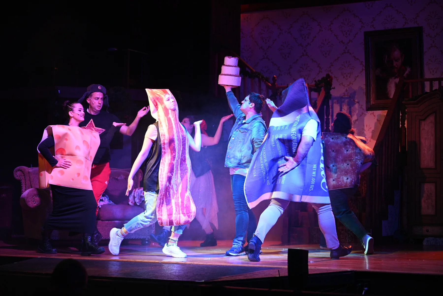 The 2025 cast dances across the stage with oversized gifts.